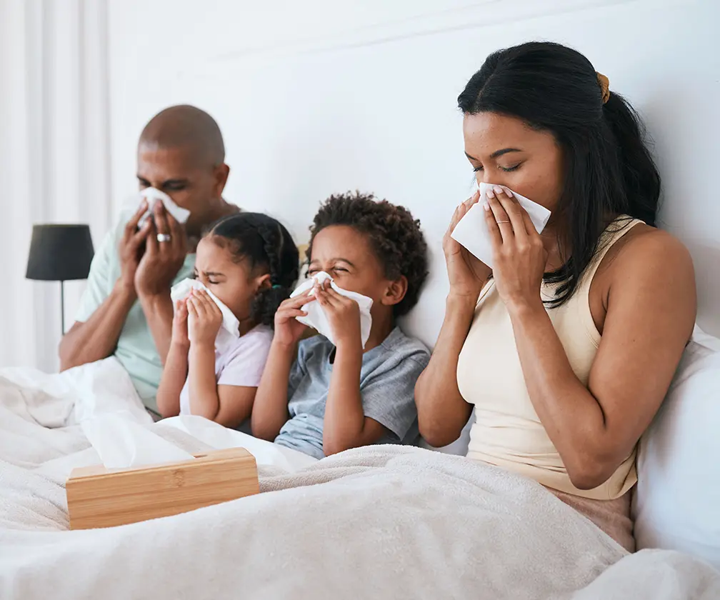 Photo of two parents and two children home sick with respiratory condition