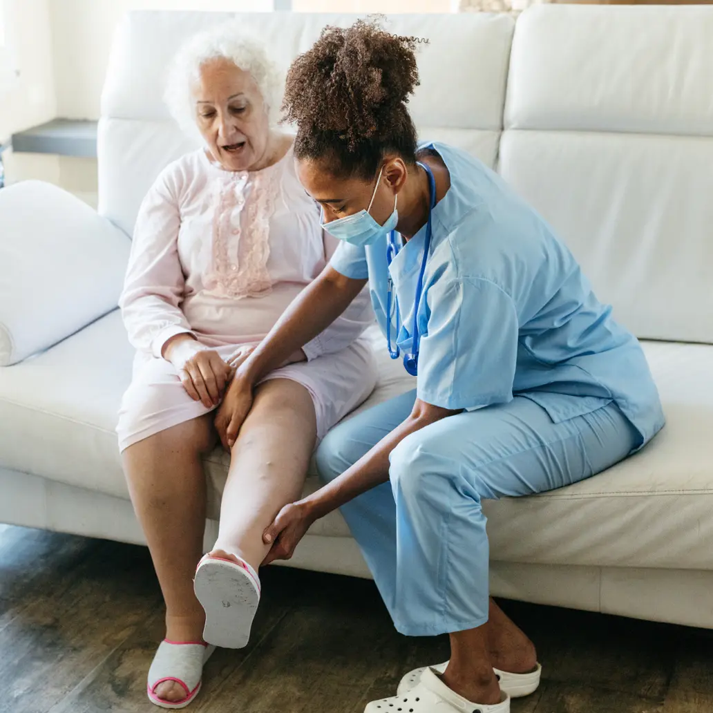 photo of female lymphedema patient having her leg examined by a female medical professional