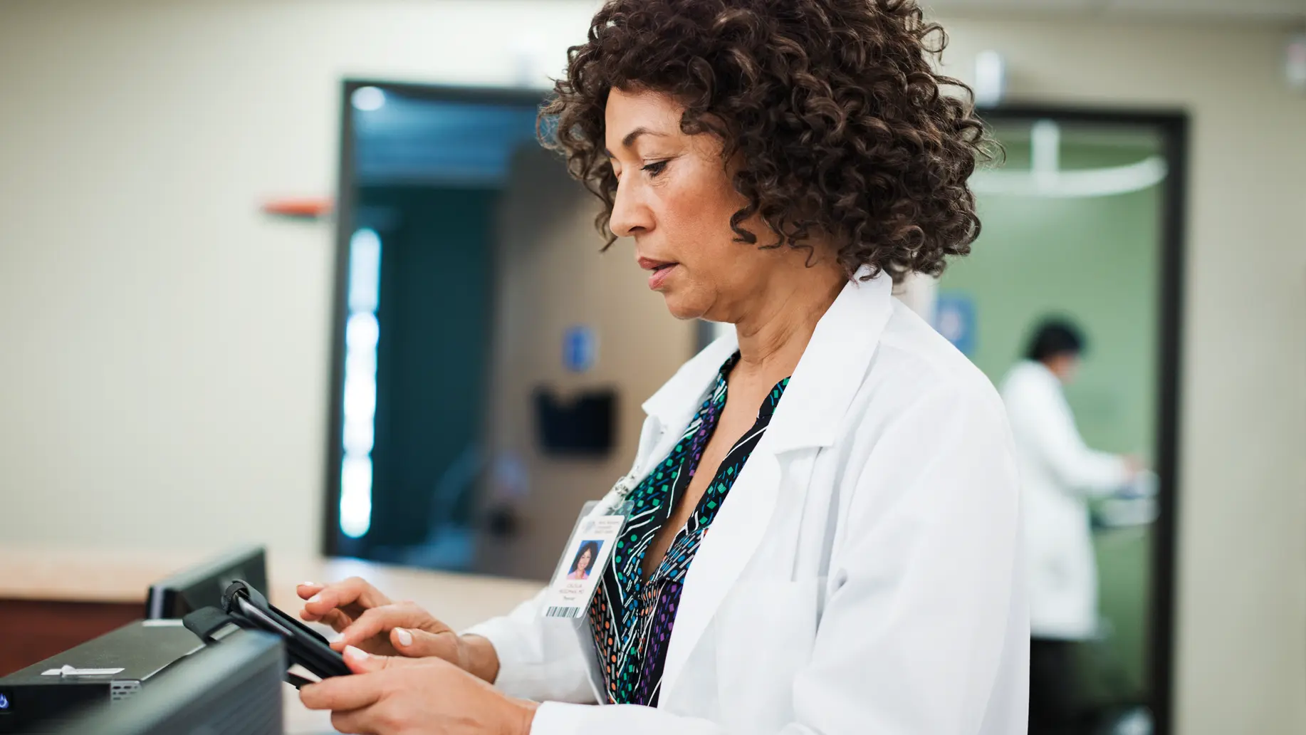 photo of a female medical professional using a mobile device in a medical office