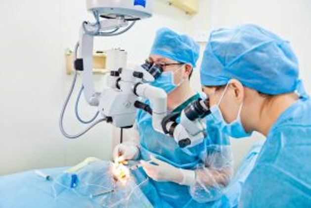 photo of 2 surgeons in an operating room working on a patient