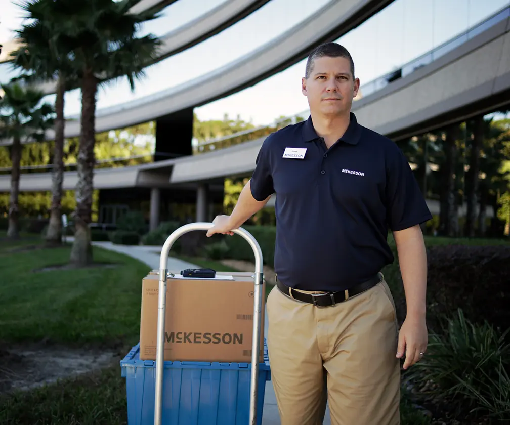 photo of McKesson employee with a dolly full of McKesson packages for delivery