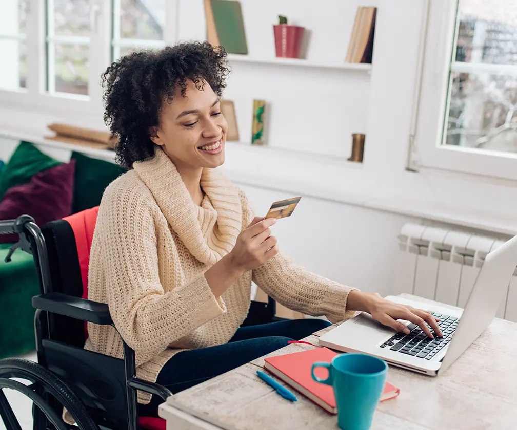 photo of a female customer using a credit card to make an online purchase