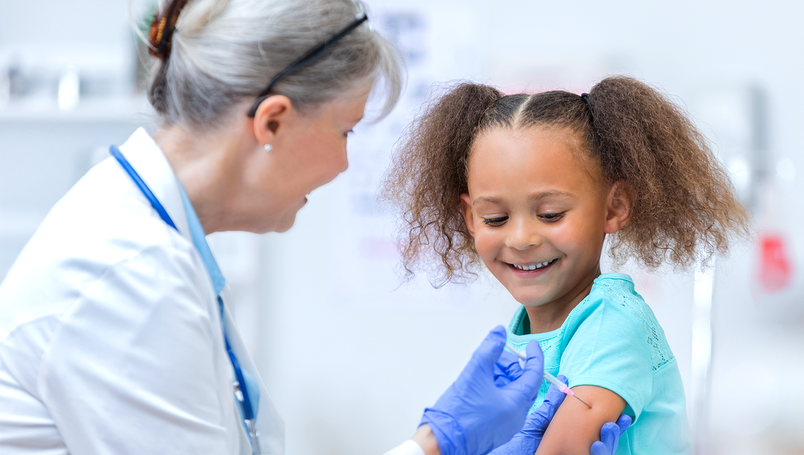photo of female doctor performing a vaccination on a child patient's arm