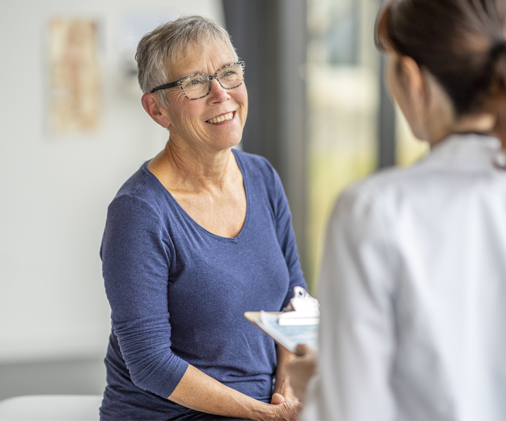 Older woman sitting in front of a doctor in a white lab coat
