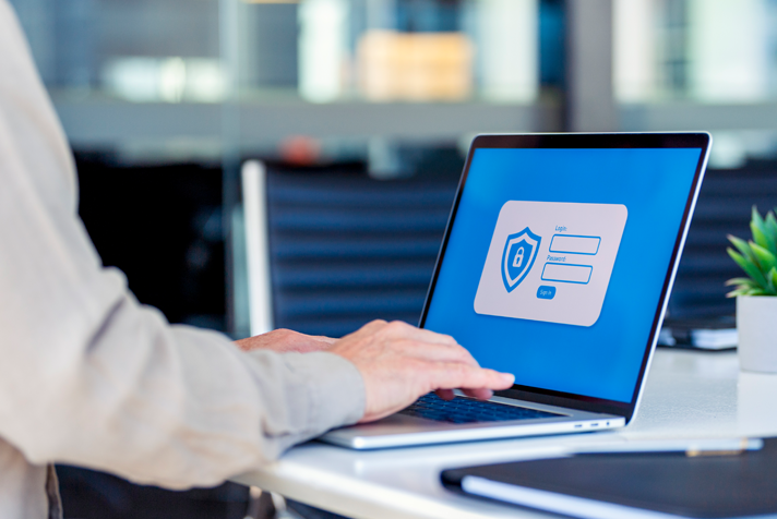 photo of someone using a laptop with security icons appearing on a login screen