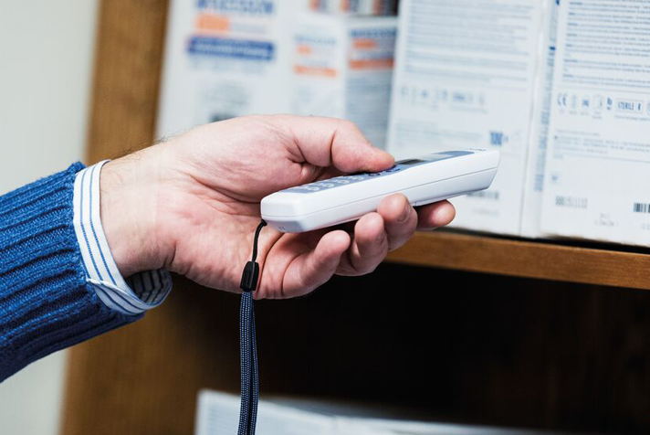 photo of a handheld scanner being used to scan products on a shelf