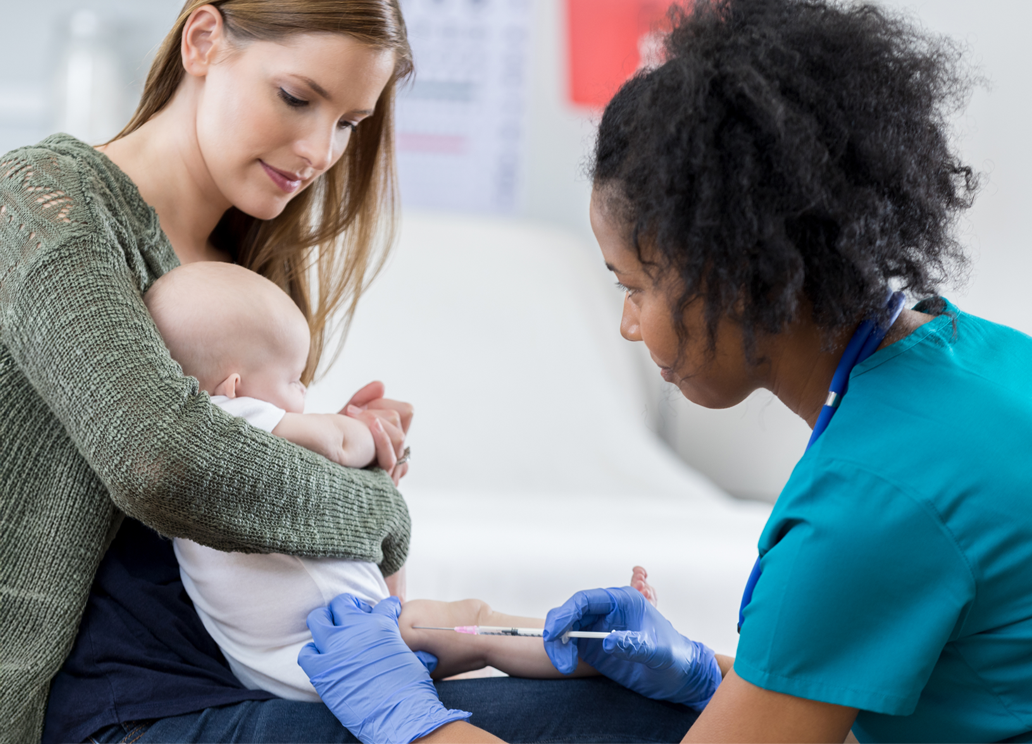 Medical professional giving a baby a vaccine while a mother holds the child