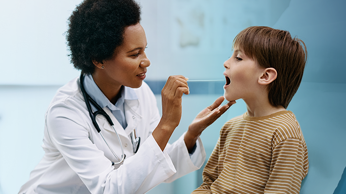 photo of female doctor swabbing a young patient's mouth