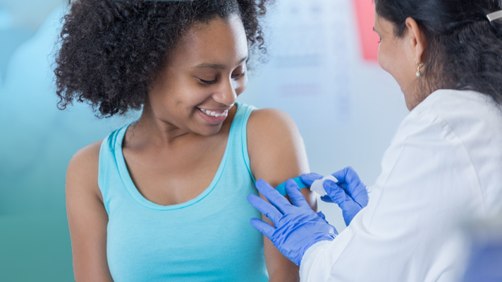photo of a female nurse administering a vaccine shot to a female patient