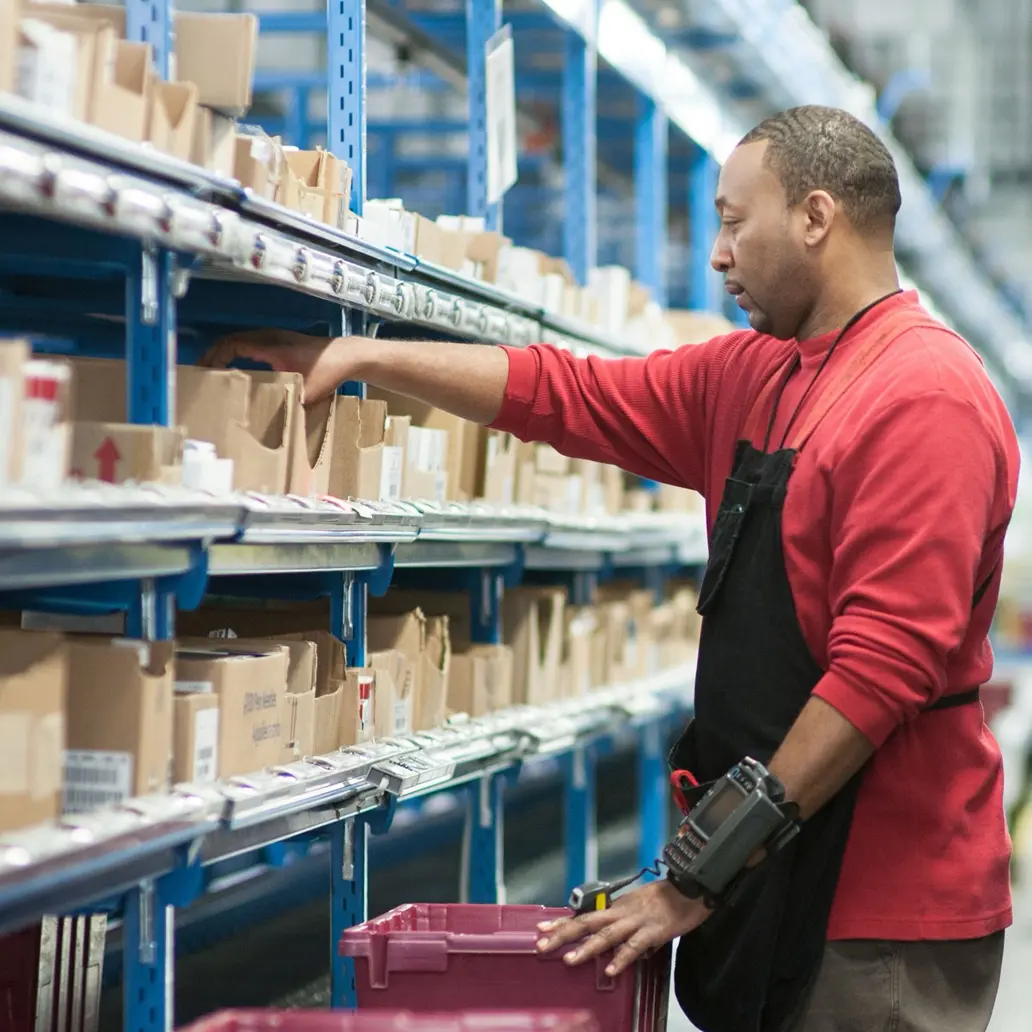 photo of male distribution worker sorting inventory in a warehouse