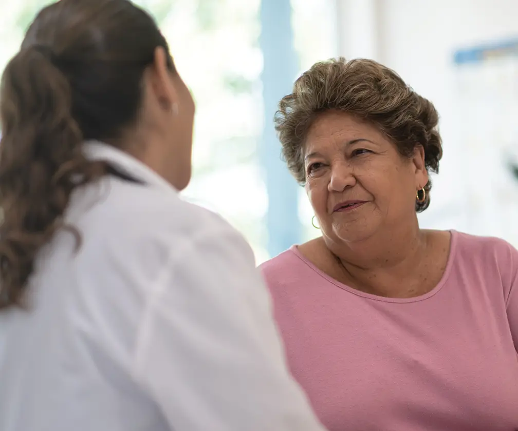 photo of a female medical professional consulting with an older female patient in a clinic setting