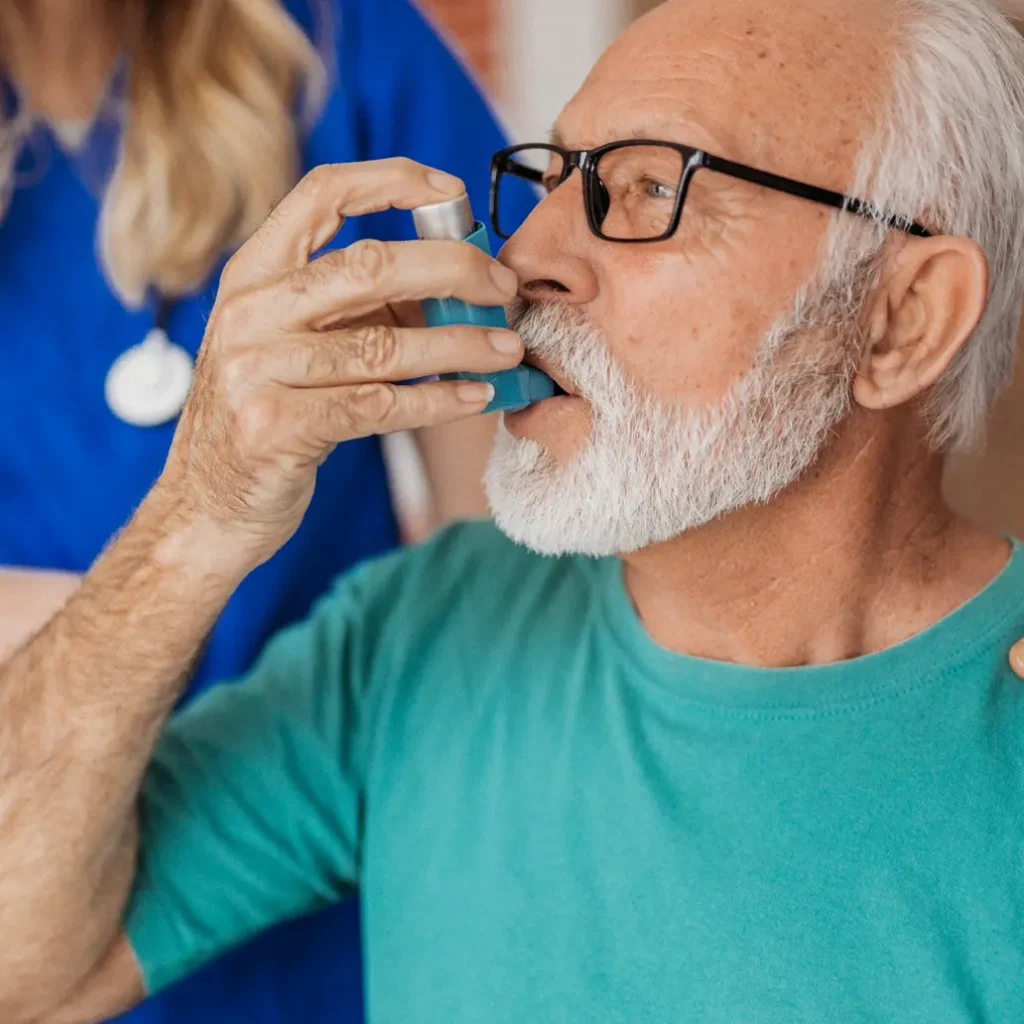 photo of an older male patient using a bronchodilator