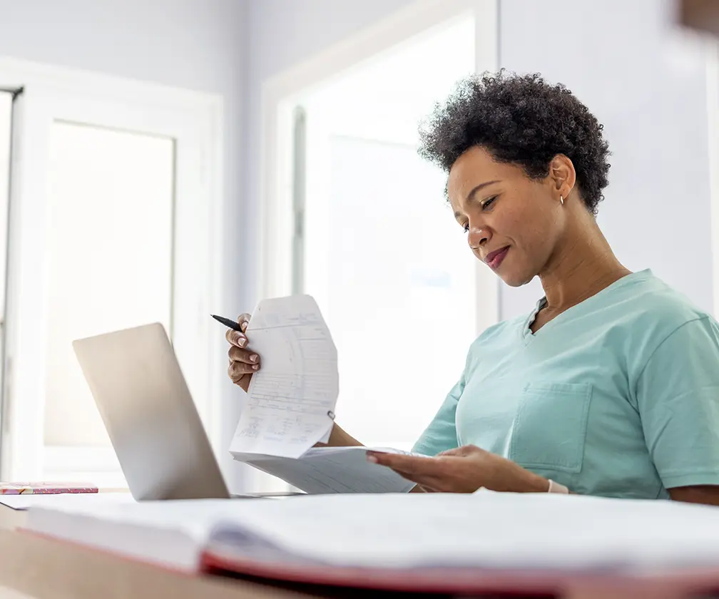 photo of a woman looking over a multi-page invoice