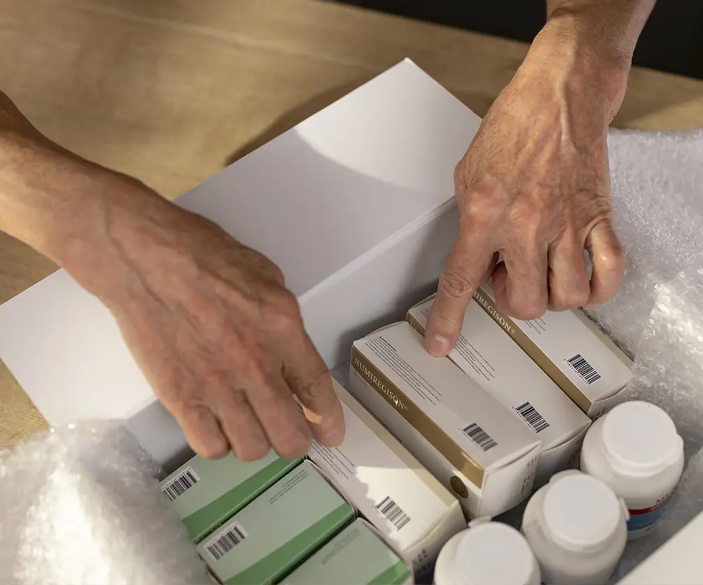 photo of person packing packages of medication into a box